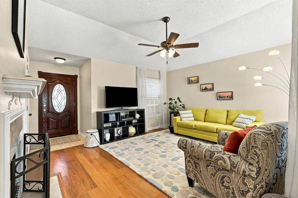 2524 Brooke Trail, Carrollton, TX 75006 Warm and inviting living room with laminate flooring, ceiling fan, and gas log fireplace.