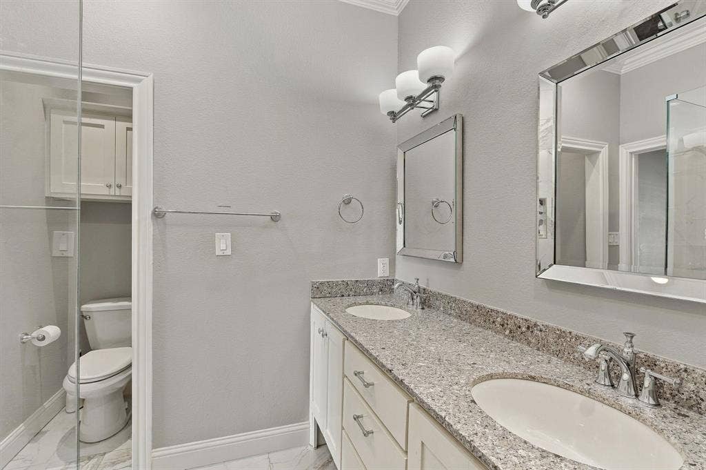 510 E Malone Street, Celina, TX 75009 Double vanity with stone countertop, dual undermount sinks, white cabinetry, and polished chrome fixtures
