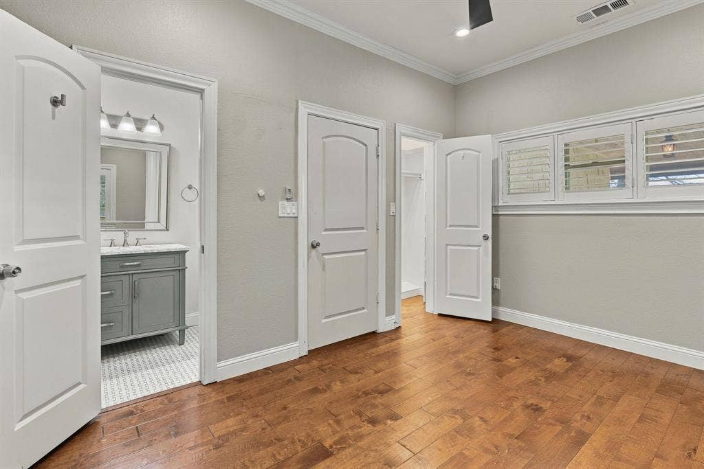 510 E Malone Street, Celina, TX 75009 Room with wood-finish flooring, crown molding, multi-panel doors, and windows featuring plantation shutters