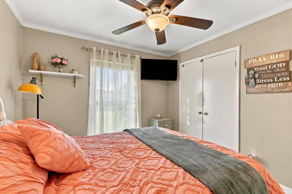 2117 Northmoor Drive, Carrollton, TX 75006 Room featuring a ceiling fan with integrated lighting, a single wall-mounted shelving unit, and a double-door reach-in closet
