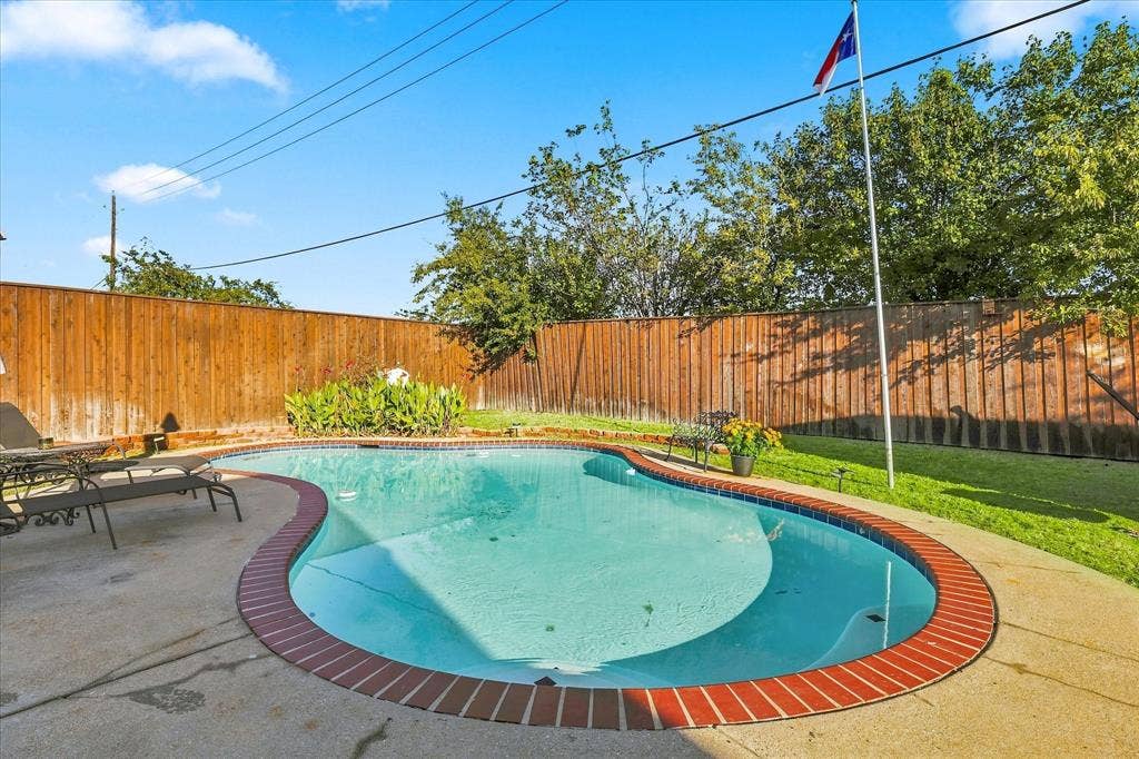 2117 Northmoor Drive, Carrollton, TX 75006 In-ground pool with brick coping, concrete patio, and fenced backyard