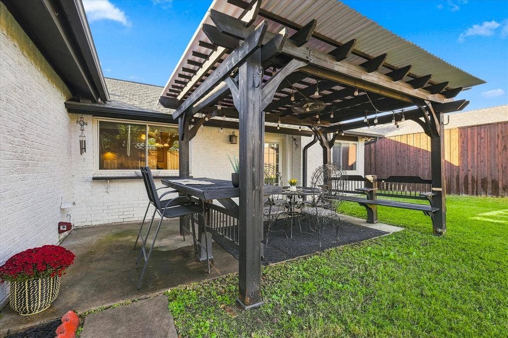 2117 Northmoor Drive, Carrollton, TX 75006 Covered patio featuring a timber-frame pergola, concrete flooring, and exterior brick siding
