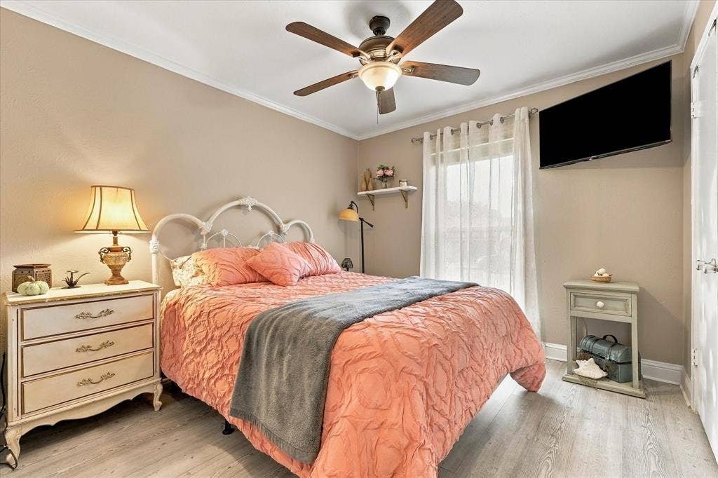 2117 Northmoor Drive, Carrollton, TX 75006 Wood-finish flooring, ceiling fan with integrated light fixture, window with sheer drapery, and a wall-mounted shelf