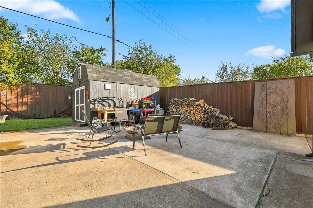 2117 Northmoor Drive, Carrollton, TX 75006 Concrete patio featuring a detached storage shed and wood privacy fencing