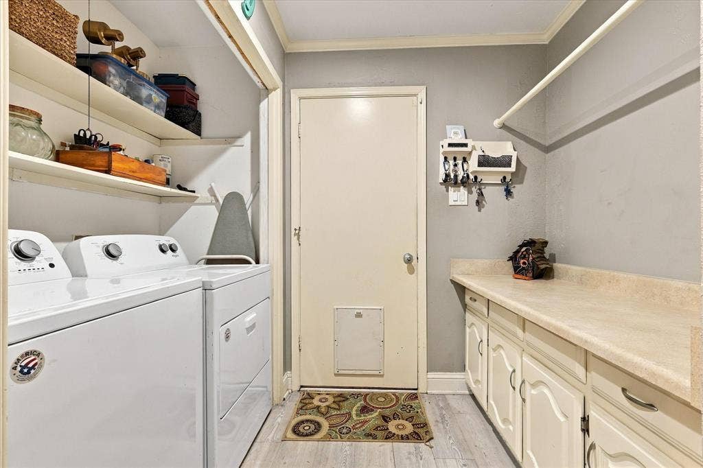 2117 Northmoor Drive, Carrollton, TX 75006 Laundry room featuring wood-finish flooring, white cabinetry with countertops, open shelving, and a door with a built-in pet portal