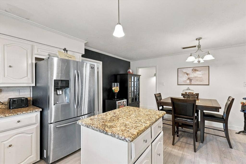 2117 Northmoor Drive, Carrollton, TX 75006 Kitchen featuring white cabinetry, stone-finish countertops, stainless steel refrigerator, center island, and wood-finish flooring