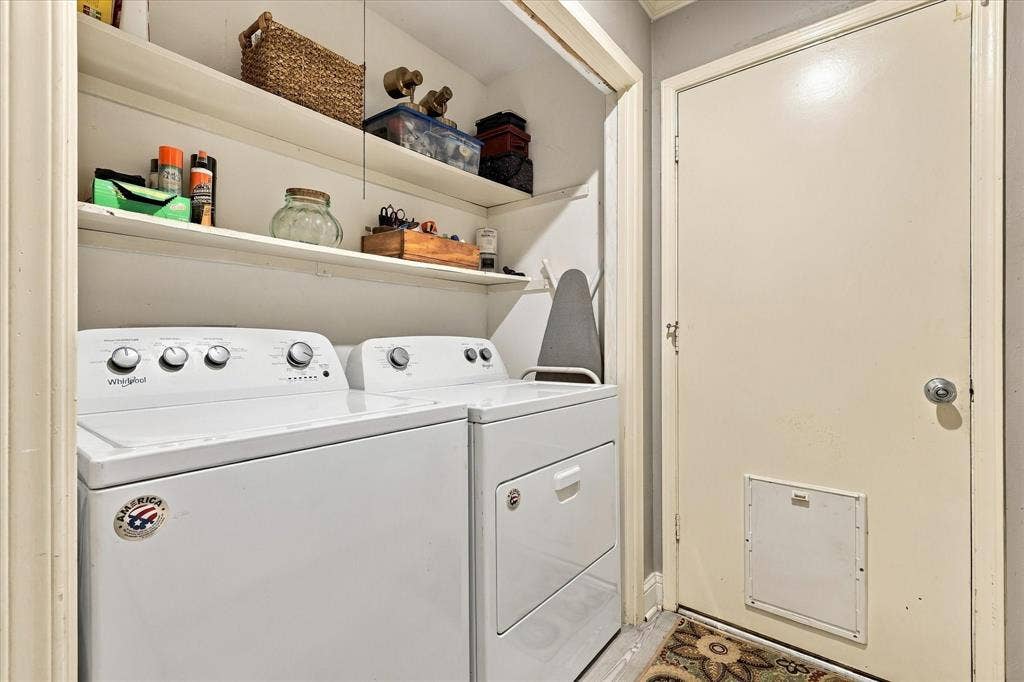 2117 Northmoor Drive, Carrollton, TX 75006 Laundry area featuring two levels of built-in shelving, white laundry appliances, and a solid-core door with a built-in pet portal