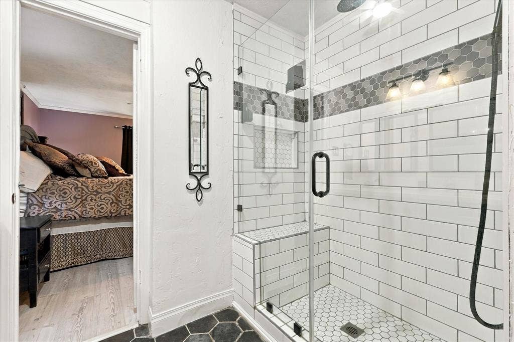 2117 Northmoor Drive, Carrollton, TX 75006 Walk-in shower featuring subway tile surround, built-in bench, hexagon tile flooring, integrated tile niche, and frameless glass enclosure