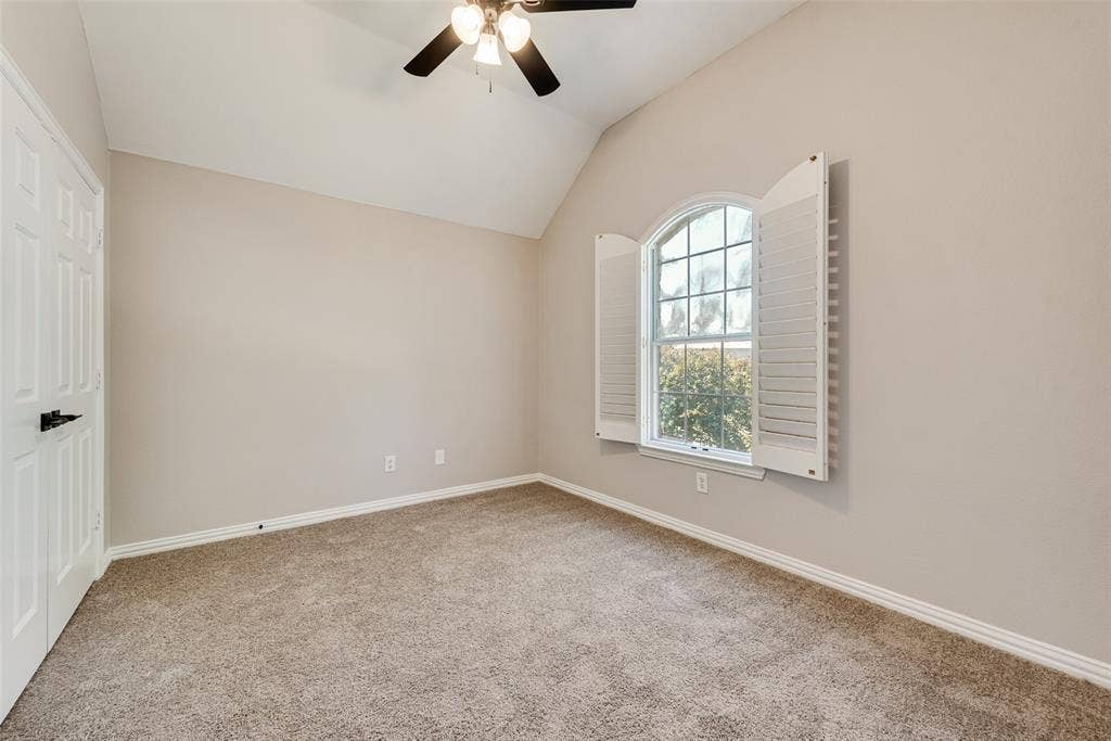 2017 Lunenburg Drive, Allen, TX 75013 Vaulted ceiling room featuring neutral carpeting, arched window with white louvered shutters, and ceiling fan with integrated lighting