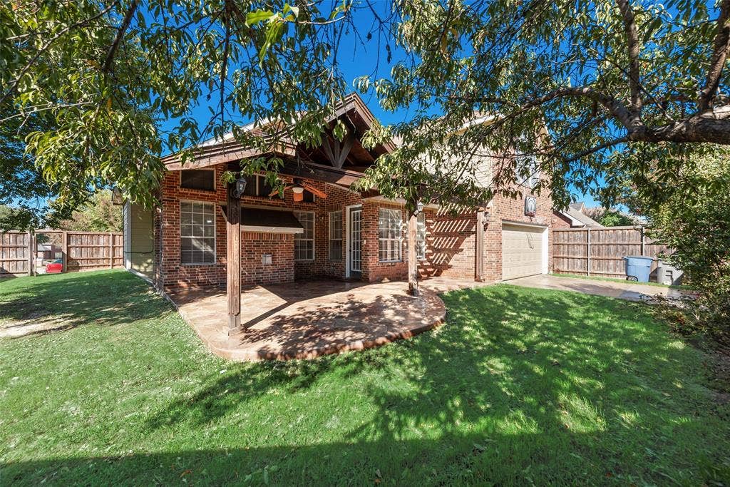 2017 Lunenburg Drive, Allen, TX 75013 Brick exterior featuring a covered patio, exposed timber framing, dual-pane windows, and attached garage