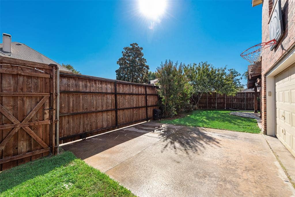 2017 Lunenburg Drive, Allen, TX 75013 Private backyard featuring a wooden privacy fence, concrete patio, and mature trees