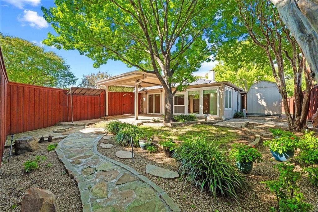 1508 Heidi Drive, Plano, TX 75025 Extensive flagstone walking path - view of storage building - lovely shade trees 8 ft board on board cedar fencesteel posts on driveway side
