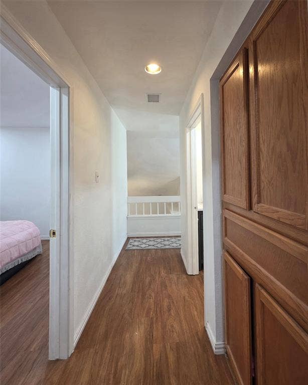 9436 Penny Lane, Irving, TX 75063 Hallway featuring wood-finish flooring, built-in wooden cabinetry, and a wooden banister