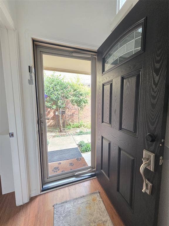9436 Penny Lane, Irving, TX 75063 Entryway featuring a dark-toned wood-grain paneled front door with an arched glass inset, brushed nickel hardware, and full-length storm door with integrated screen