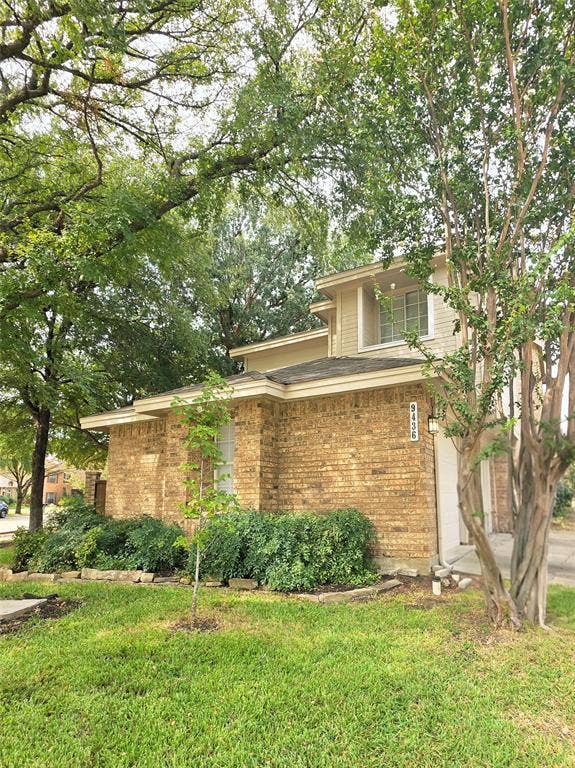 9436 Penny Lane, Irving, TX 75063 Two-story exterior featuring multi-material brick and siding facade, manicured lawn, and established trees