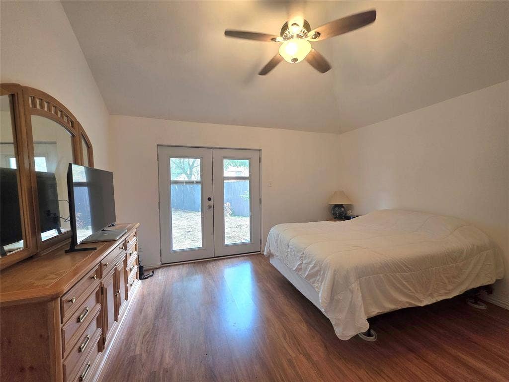 9436 Penny Lane, Irving, TX 75063 Vaulted ceiling with an integrated ceiling fan and wood-finish flooring featuring dual glass-paned doors