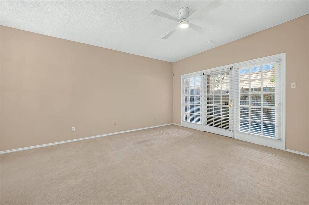 5859 Frankford Road, #1209, Dallas, TX 75252 Interior space featuring wall-to-wall carpeting, a ceiling fan with integrated lighting, and triple glass-paned doors with horizontal blinds