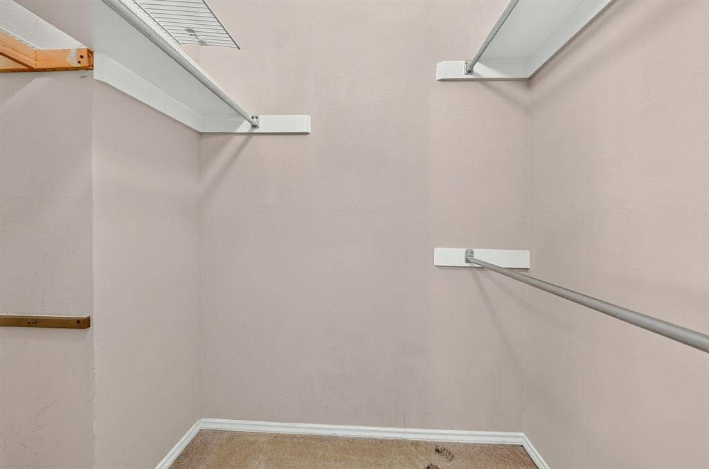 5859 Frankford Road, #1209, Dallas, TX 75252 Walk-in closet featuring white wall-mounted shelving and integrated metal hanging rods