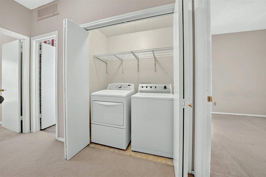 5859 Frankford Road, #1209, Dallas, TX 75252 Laundry closet featuring bifold doors and integrated overhead wire shelving