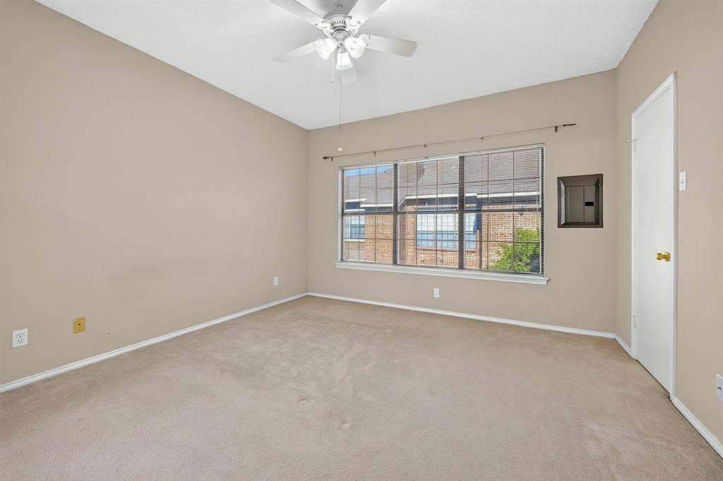 5859 Frankford Road, #1209, Dallas, TX 75252 Neutral-toned interior featuring wall-to-wall carpeting, a multi-blade ceiling fan, and a large multi-pane window