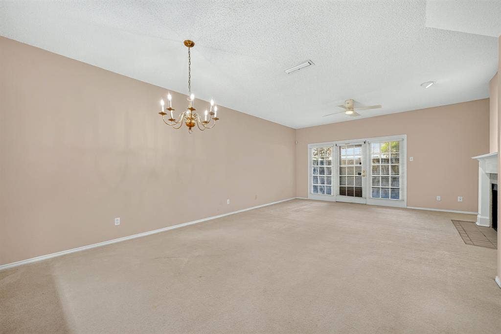 5859 Frankford Road, #1209, Dallas, TX 75252 Open living area featuring a traditional multi-arm chandelier, ceiling fan, fireplace with a mantle, and glass-paned French doors