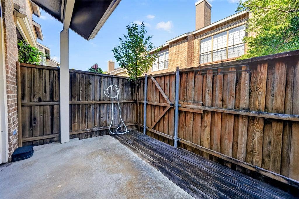 5859 Frankford Road, #1209, Dallas, TX 75252 Private courtyard featuring a concrete patio, wood-finish decking, and wood privacy fencing