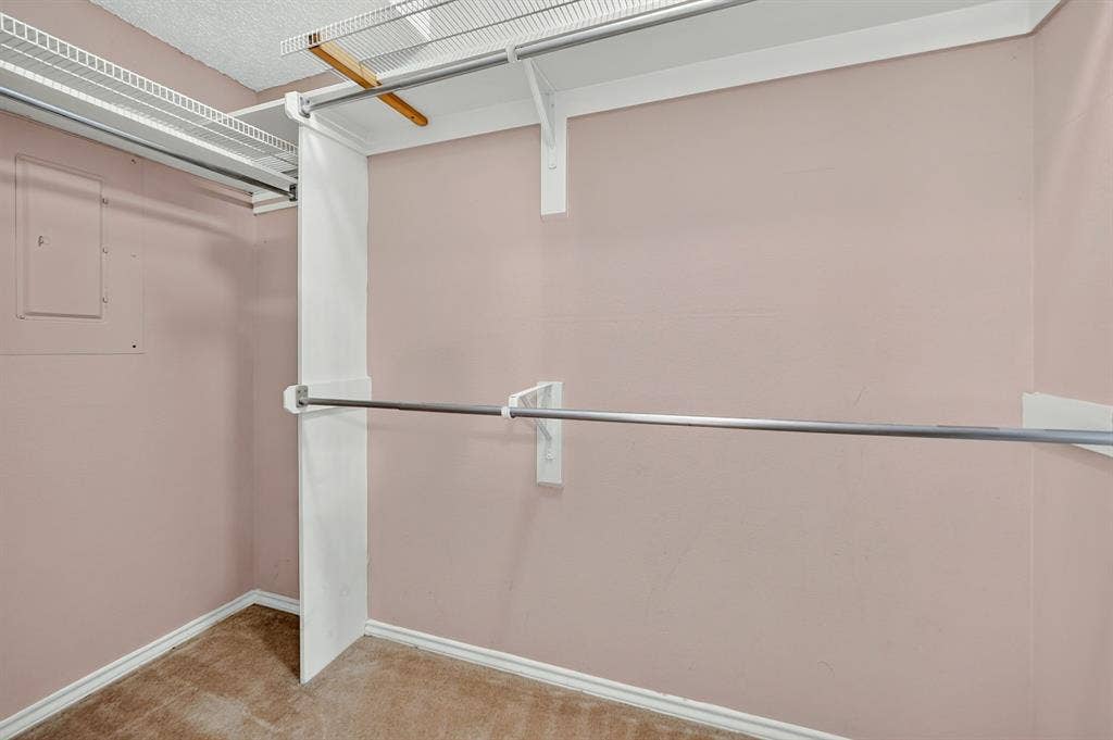 5859 Frankford Road, #1209, Dallas, TX 75252 Walk-in closet featuring multi-level metal hanging rods, built-in wire shelving, and neutral wall-to-wall carpeting
