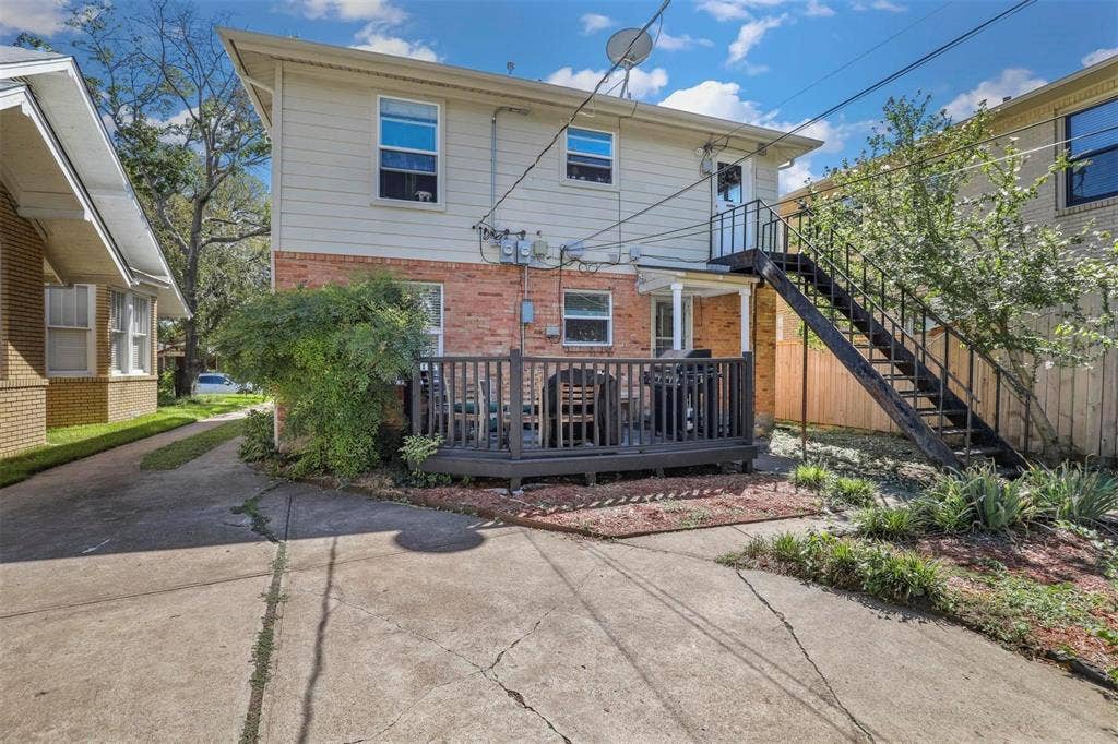 5925 Victor Street, Dallas, TX 75214 Exterior featuring brick and horizontal siding, a raised wood-finish deck with railings, and a metal staircase