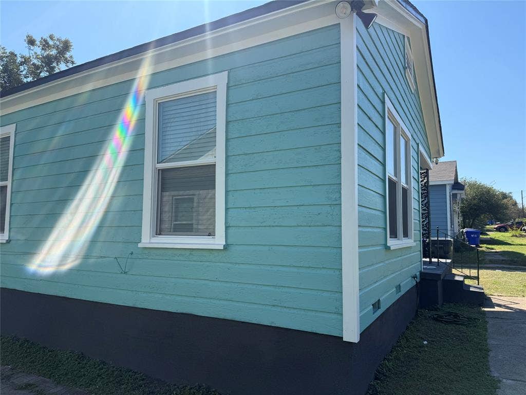 2716 Lyle Avenue, Waco, TX 76708 Exterior siding finished in a vibrant blue-green tone with contrasting white trim, horizontal lap cladding, and dual-pane windows