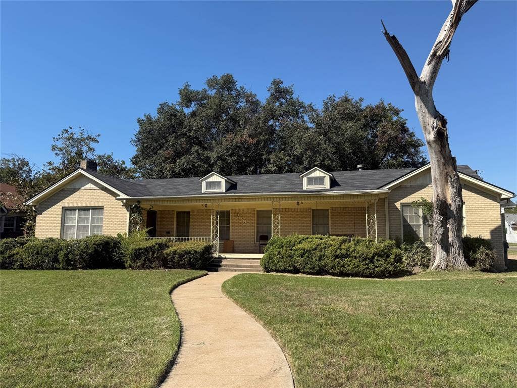 2301 Bosque Boulevard, Waco, TX 76707 Single-story brick exterior featuring a covered front porch, dual dormers, and a paved walkway