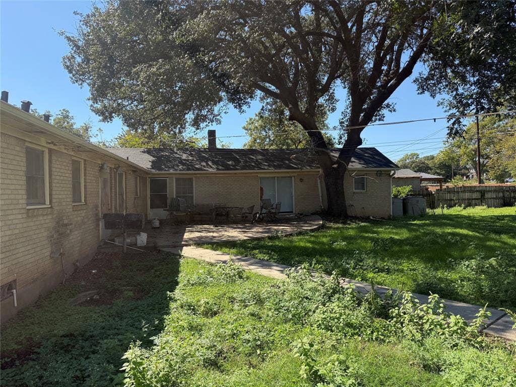 2301 Bosque Boulevard, Waco, TX 76707 Exterior brick facade featuring a concrete patio, paved walkway, and mature tree canopy