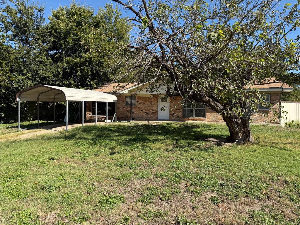 4916 Inwood Drive, Beverly Hills, TX 76711 Single-story brick exterior featuring a metal-frame carport, paved driveway, and mature landscaping