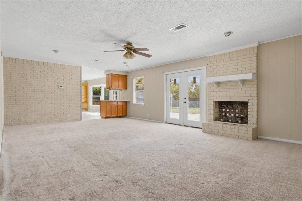 2729 Tanglewood Drive, Commerce, TX 75428 Huge living area with fireplace and double doors to the outside
