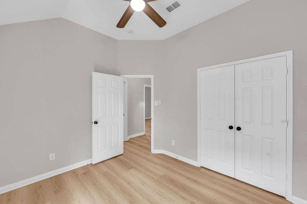 12109 Biloxi Drive, Frisco, TX 75035 Vaulted ceiling with a central paddle fan, wood-finish flooring, and double-door closet cabinetry