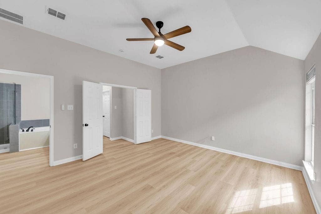 12109 Biloxi Drive, Frisco, TX 75035 Vaulted ceiling featuring a central five-blade light fixture, neutral wall finishes, wood-finish flooring, and double-door entry