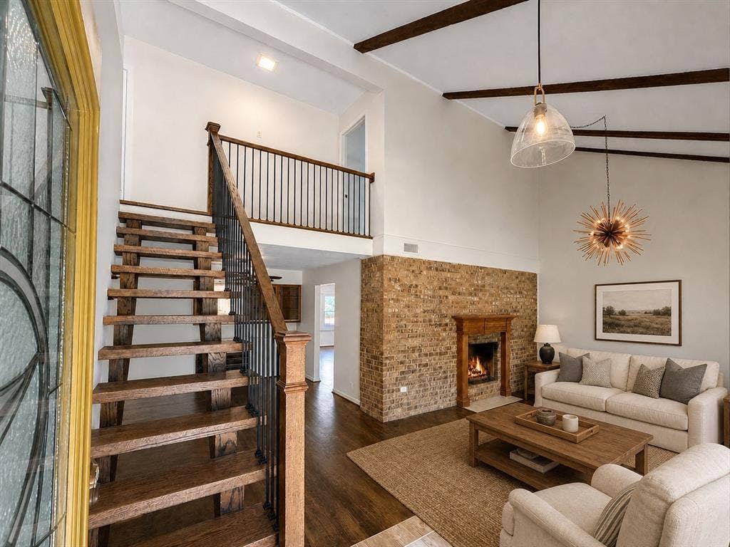 3210 Cortez Court W, Irving, TX 75062 Exposed wood ceiling beams, brick fireplace surround, open-tread staircase with metal balusters, and vaulted ceilings