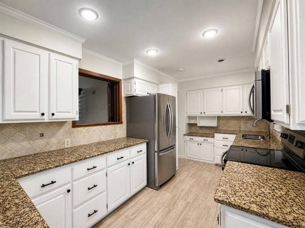 3210 Cortez Court W, Irving, TX 75062 Kitchen featuring white cabinetry, stone-finish countertops, tile backsplash, stainless steel appliances, and wood-finish flooring