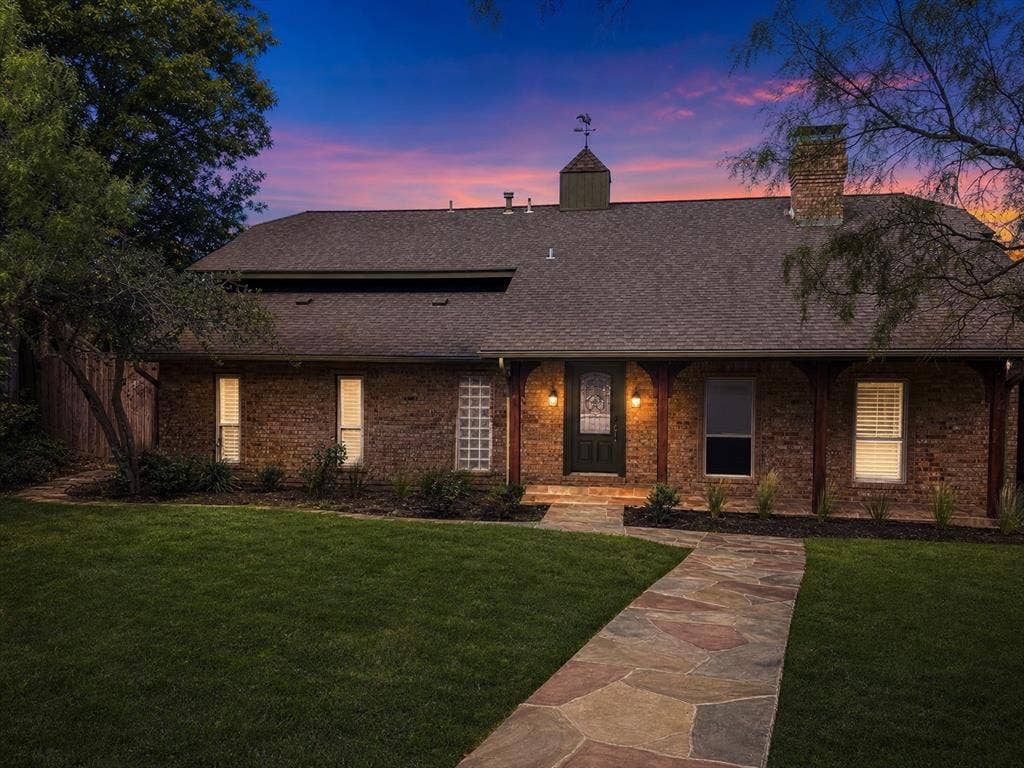 3210 Cortez Court W, Irving, TX 75062 Brick exterior featuring a multi-gabled roofline, a decorative cupola with a weathervane, natural stone walkway, and a covered front porch with timber support posts