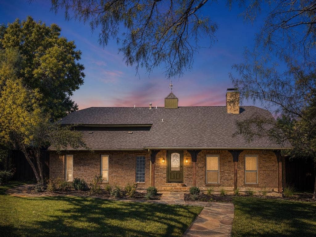 3210 Cortez Court W, Irving, TX 75062 Brick exterior featuring a roof cupola, covered front porch with decorative corbels, stone walkway, and chimney