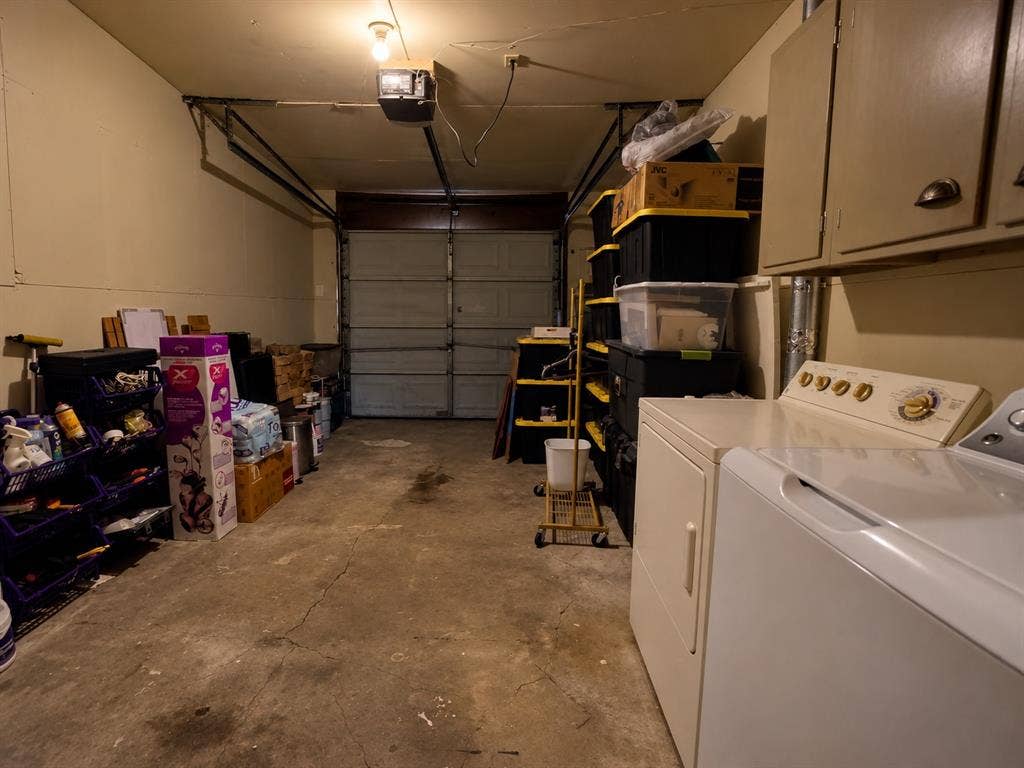 Garage featuring a sectional overhead door, concrete flooring, and built-in wall-mounted cabinetry