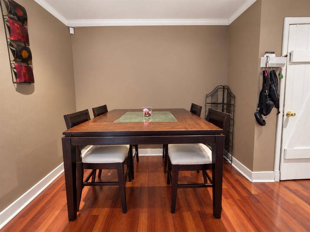 Wood-finish flooring, crown molding, and a solid-core door with brass hardware