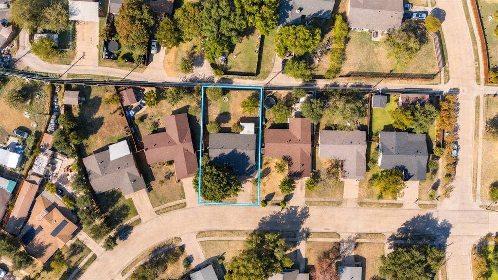 907 Crest Park Drive, Garland, TX 75042 Aerial perspective of a residential property featuring an expansive backyard, mature landscaping, and a rectangular lot configuration