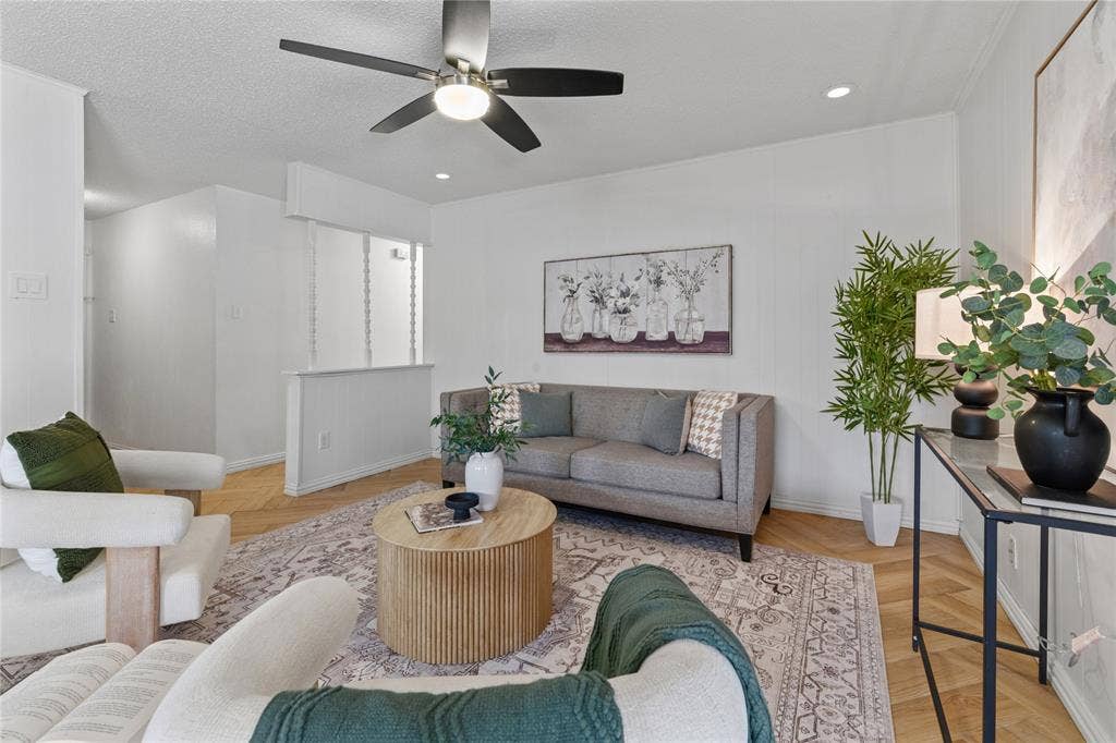 907 Crest Park Drive, Garland, TX 75042 Herringbone-patterned wood-finish flooring, brushed nickel ceiling fan with integrated lighting, and a half-wall partition featuring vertical spindle accents