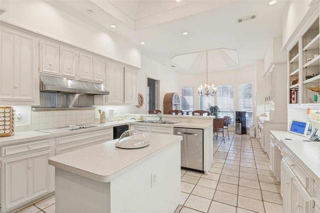 6215 Raintree Court, Dallas, TX 75254 Kitchen featuring white cabinetry, center island, stainless steel range hood, tile flooring, and recessed lighting