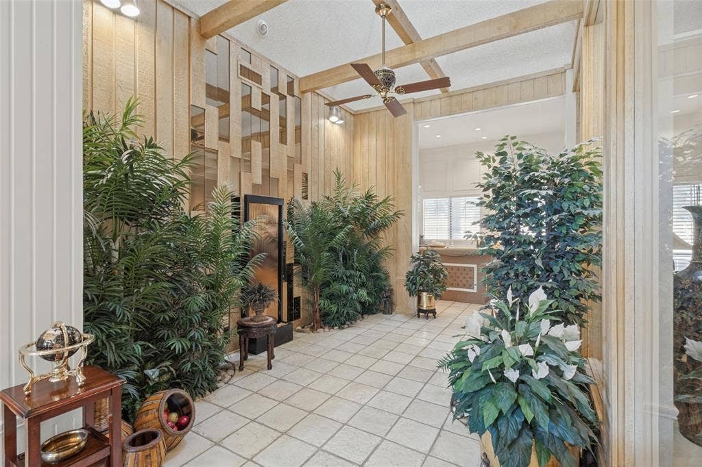 6215 Raintree Court, Dallas, TX 75254 Interior space featuring vertical wood paneling, decorative mirror accents, exposed ceiling beams, a ceiling fan, and tile flooring