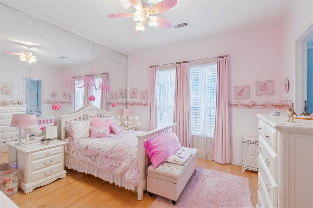 6215 Raintree Court, Dallas, TX 75254 Spacious room featuring wood-finish flooring, full-wall mirrors, dual windows with plantation shutters, and a ceiling fan with integrated lighting