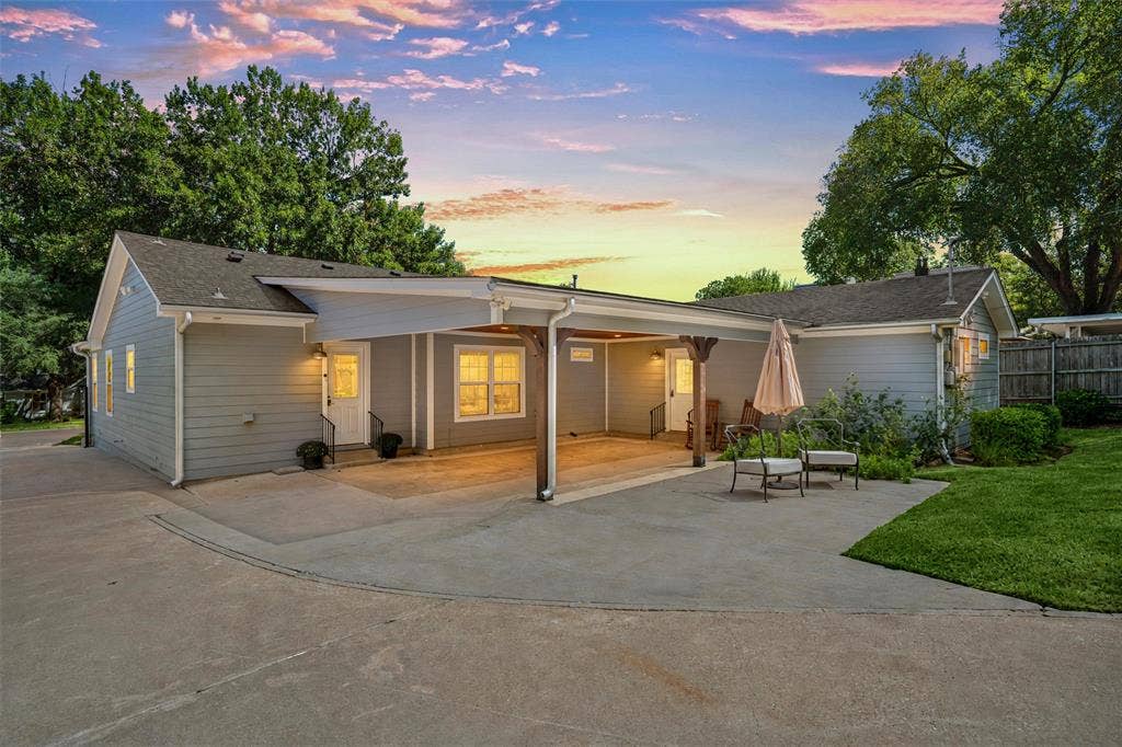 200 Oriental Road, Waco, TX 76710 Exterior featuring horizontal lap siding, a sprawling concrete driveway, an expansive covered carport with decorative wood support posts, and a manicured lawn