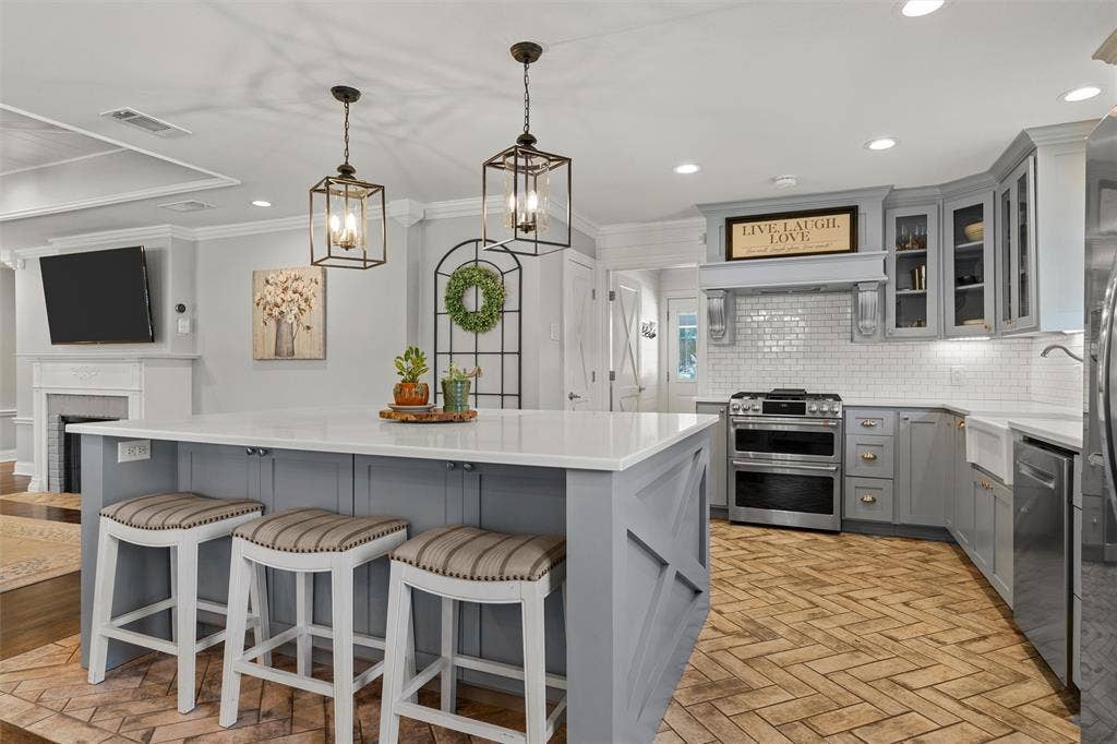 200 Oriental Road, Waco, TX 76710 Kitchen featuring a center island with quartz countertops, herringbone-pattern brick flooring, stainless steel range, white subway tile backsplash, and decorative pendant lighting