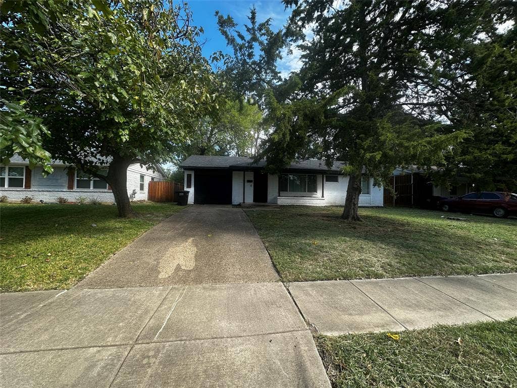 4808 Sandra Lynn Drive, Mesquite, TX 75150 Single-story residence featuring a painted masonry exterior, attached garage, concrete driveway, and mature trees
