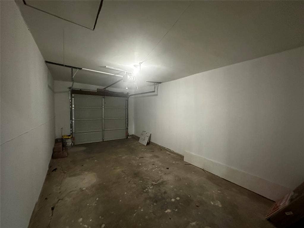 4808 Sandra Lynn Drive, Mesquite, TX 75150 Enclosed garage featuring a concrete floor, painted walls, and a sectional overhead door with an integrated automatic opener